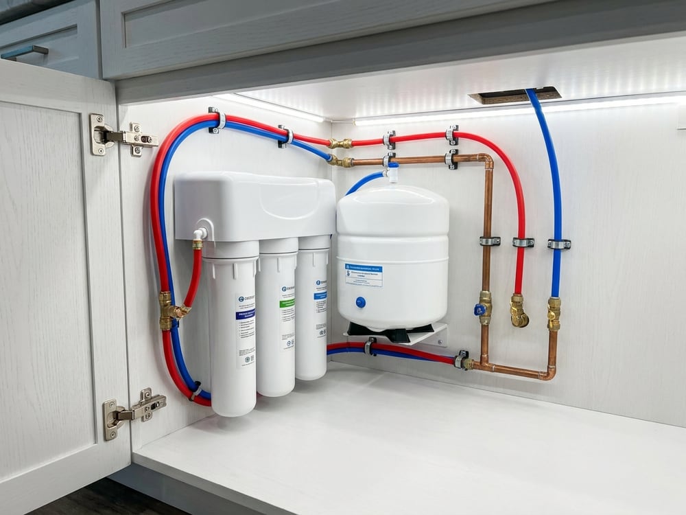 An under-sink reverse osmosis drinking water system with filter bank and storage tank